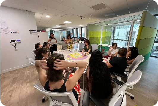 photo d'une table avec un groupe de 11 femmes assises autour, en train d'échanger